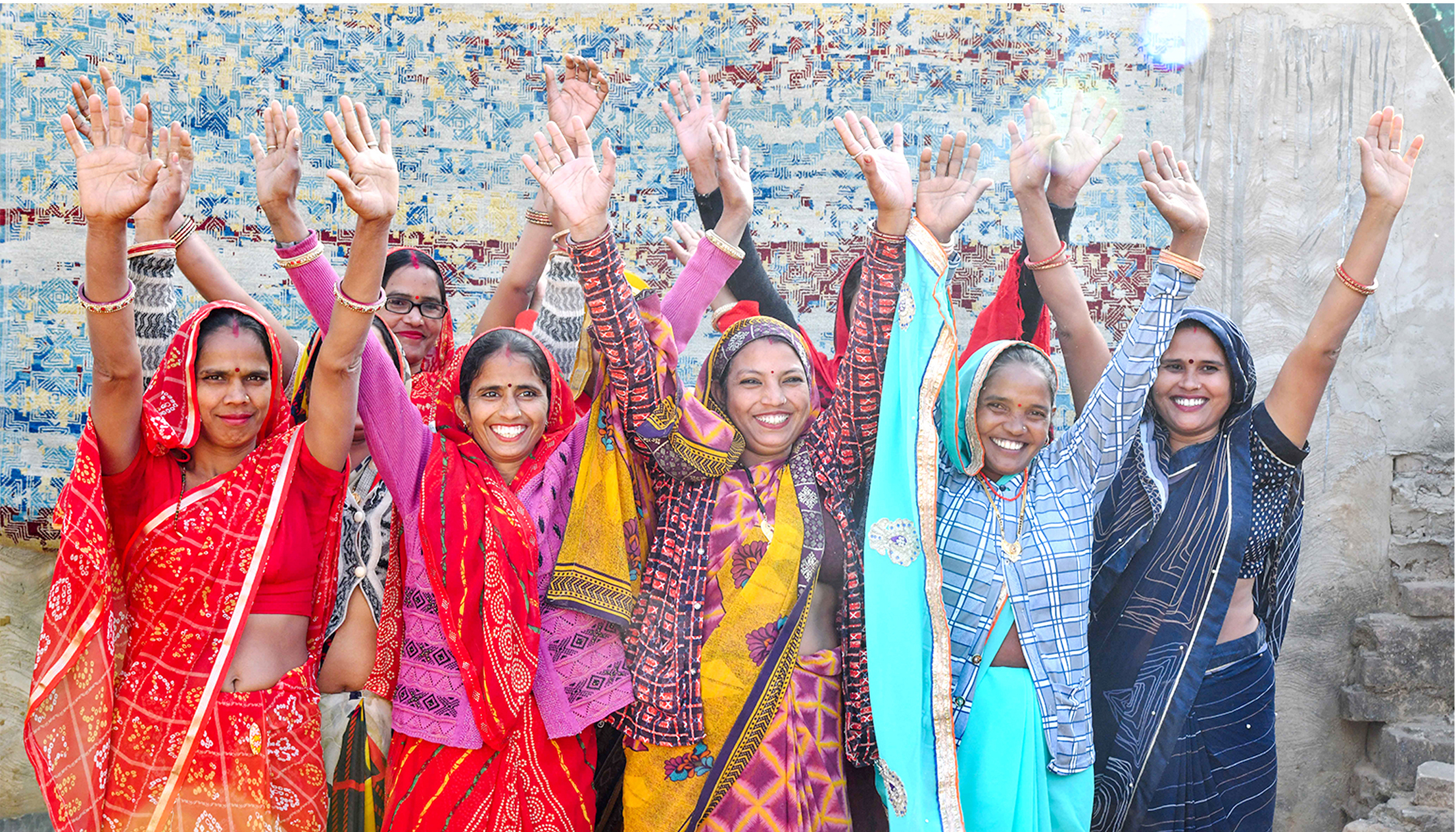 Women from artisan communities raising their hands